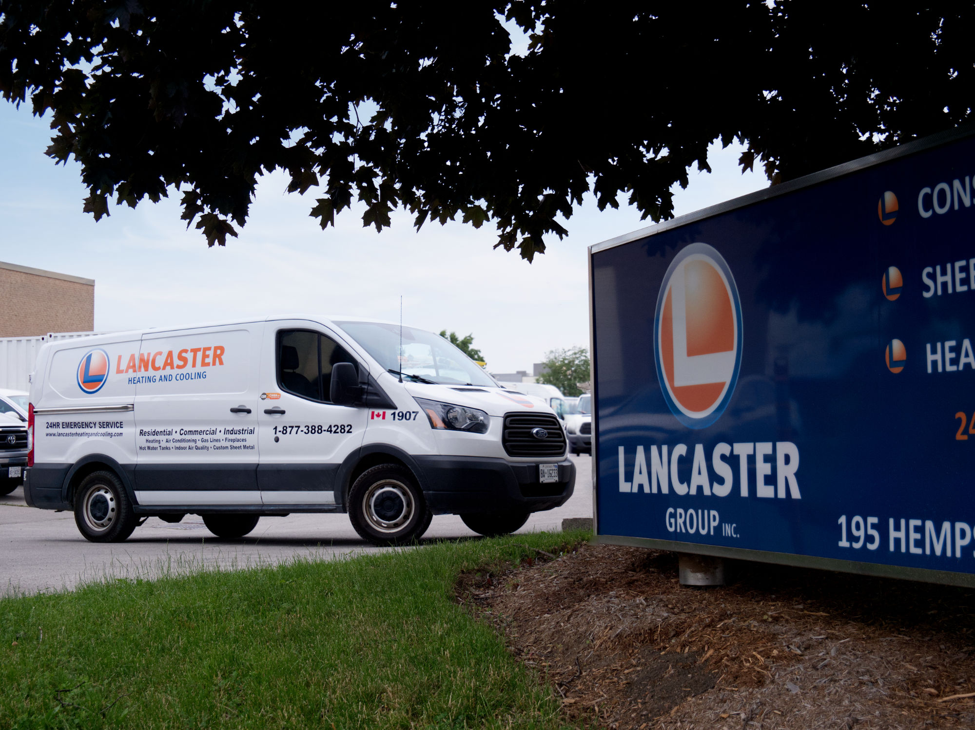 A Lancaster Heating and Cooling van parked outside The Lancaster Group Inc home office in Hamilton, ON.
