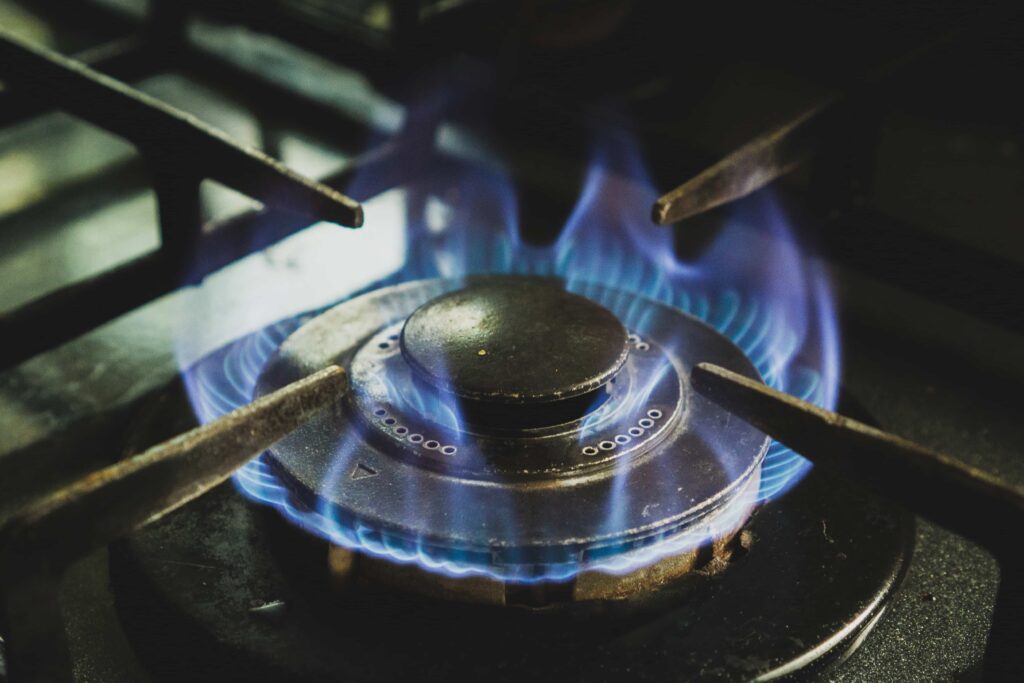 A lit burner on a gas stovetop, newly serviced.